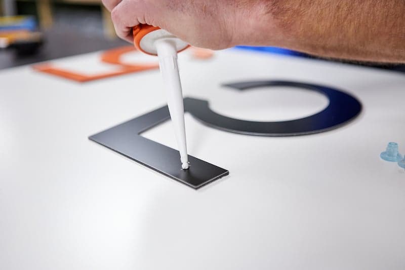 Les numéros de maison font des entretoises fixées avec du mastic